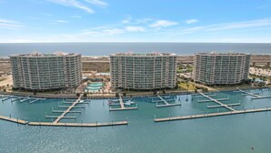 Ein Hochhaus-Hotel mit mehreren Balkonen, einer Marina mit Anlegestellen und einem Poolbereich.