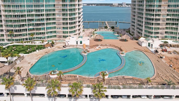 A resort with multiple swimming pools, a marina, and high-rise buildings.