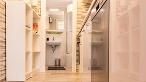 A modern kitchen with a built-in refrigerator, wooden flooring, and a central island with a sink.