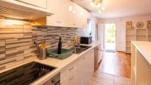 A modern kitchen with a tiled backsplash, stainless steel appliances, and a bright, well-lit space.