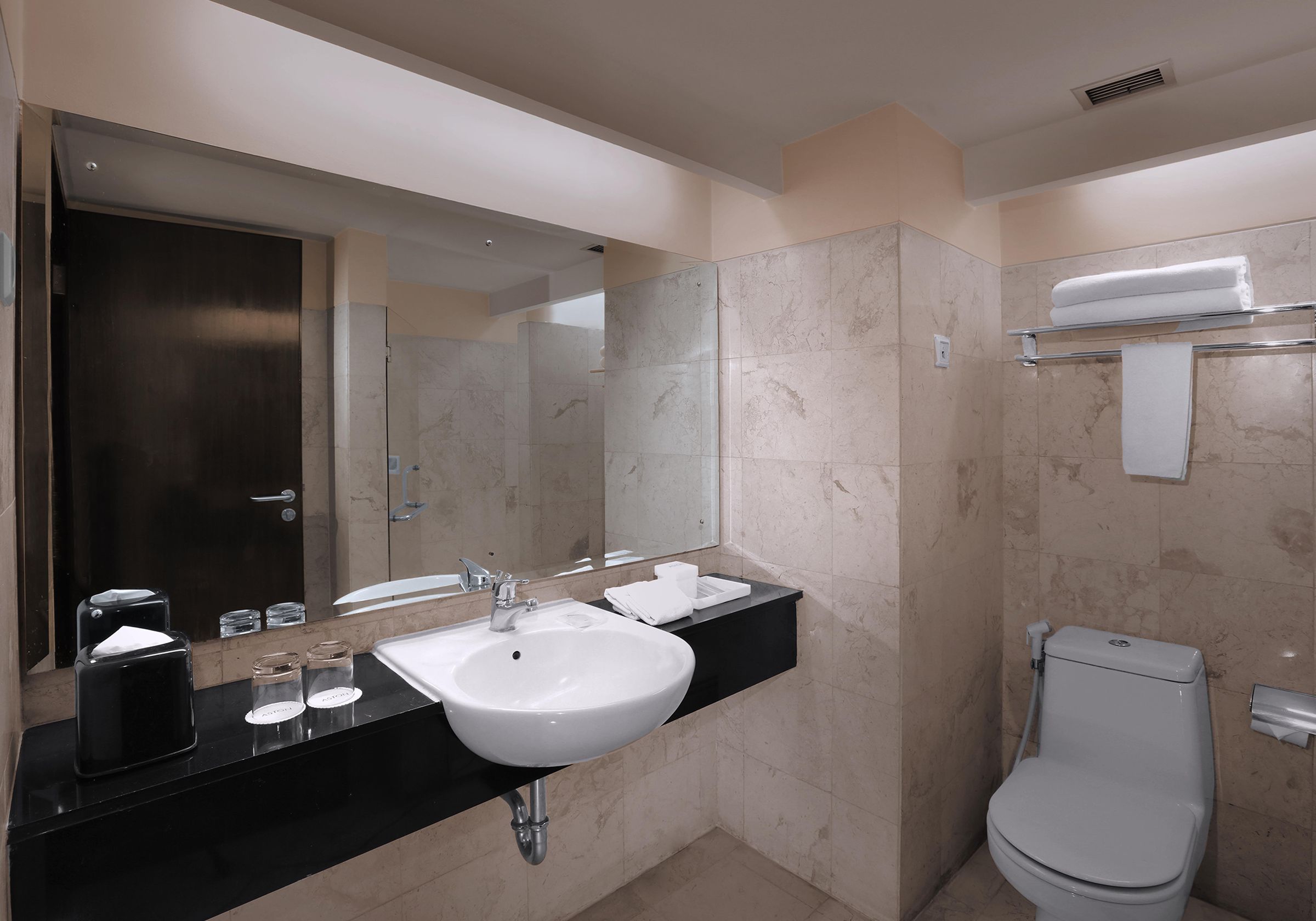 Une salle de bain moderne avec un plan de toilette noir, un lavabo blanc et des toilettes.