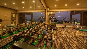 Ett gym med utrustning för styrketräning, löpband och motionscyklar.