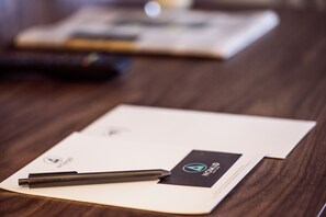 A notebook with a pen on a wooden table. - Nomad Luxury Suites (Belgrade)
