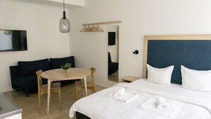 A hotel room with a bed, a round table, a chair, a small desk, and a mirror. - Studio Apartment for 4 (København)