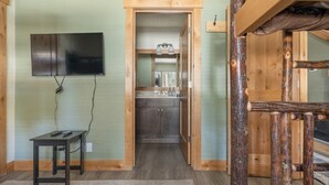 A room with a television mounted on the wall, a small table with a power cord, and a wooden log structure in the corner. - MST #1-Large townhome in heart of town. Easily sleeps 10! Beautifully updated (Mammoth Lakes)