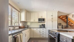A compact kitchen with white cabinets, a microwave, a coffee maker, and a built-in oven. - MST #1-Large townhome in heart of town. Easily sleeps 10! Beautifully updated (Mammoth Lakes)