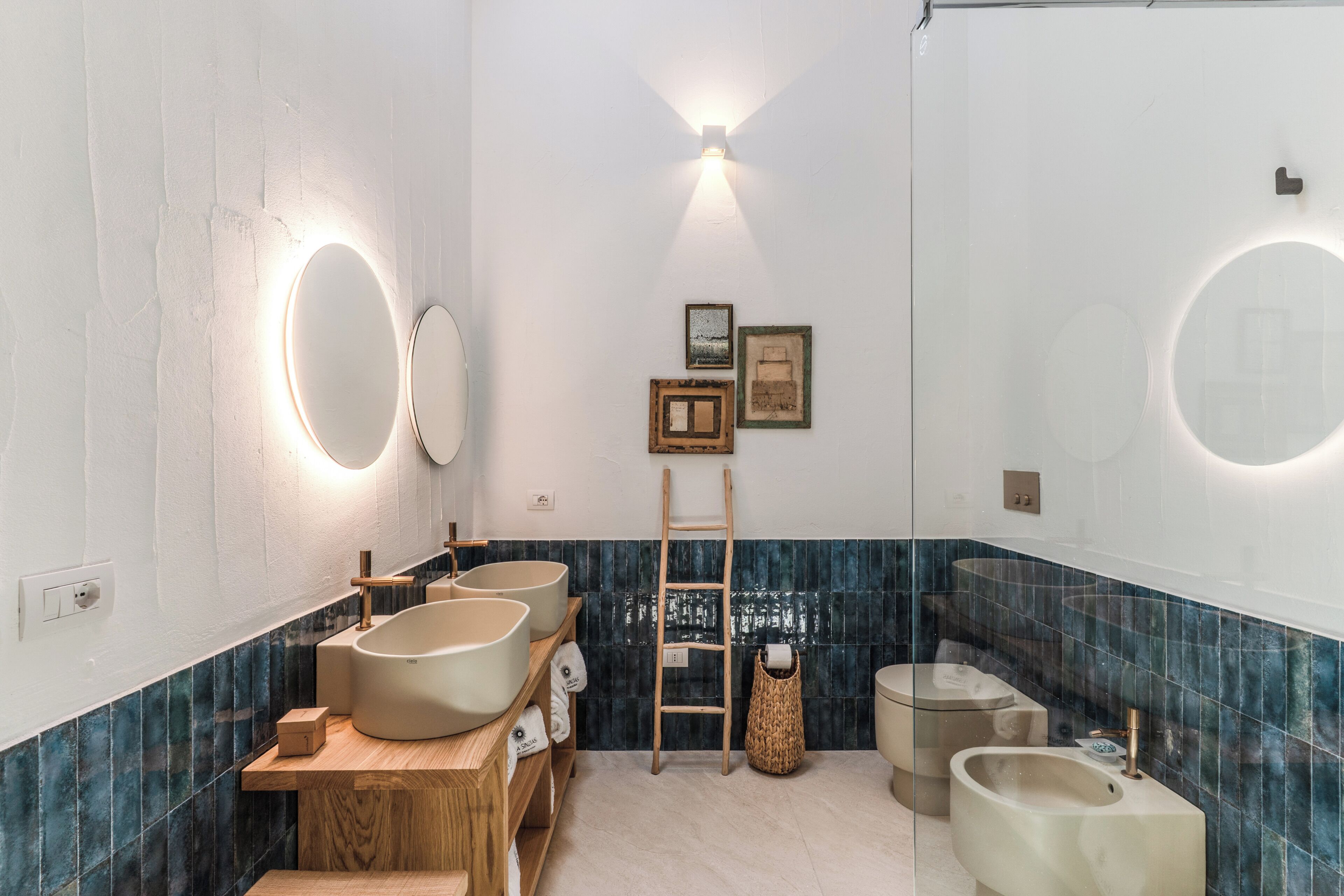 A modern bathroom with a wooden vanity, two sinks, a mirror, and a towel rack.