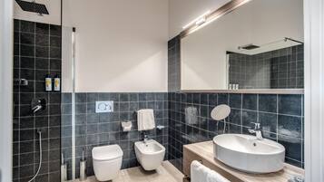Une salle de bain moderne équipée d’une douche, de toilettes, d’un bidet et d’un lavabo.