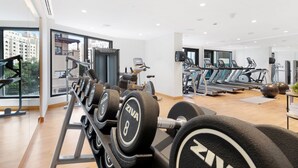 Un gimnasio moderno con varios equipos de ejercicio, incluyendo cintas de correr y mancuernas.