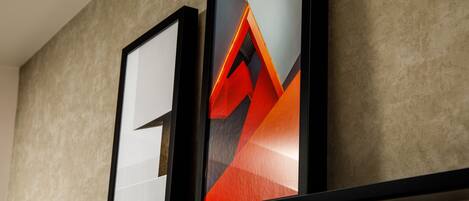 Two framed artworks on a wall with a textured surface.