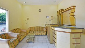 Una habitación con un conjunto de sofá, una mesita y un mueble con cajones.