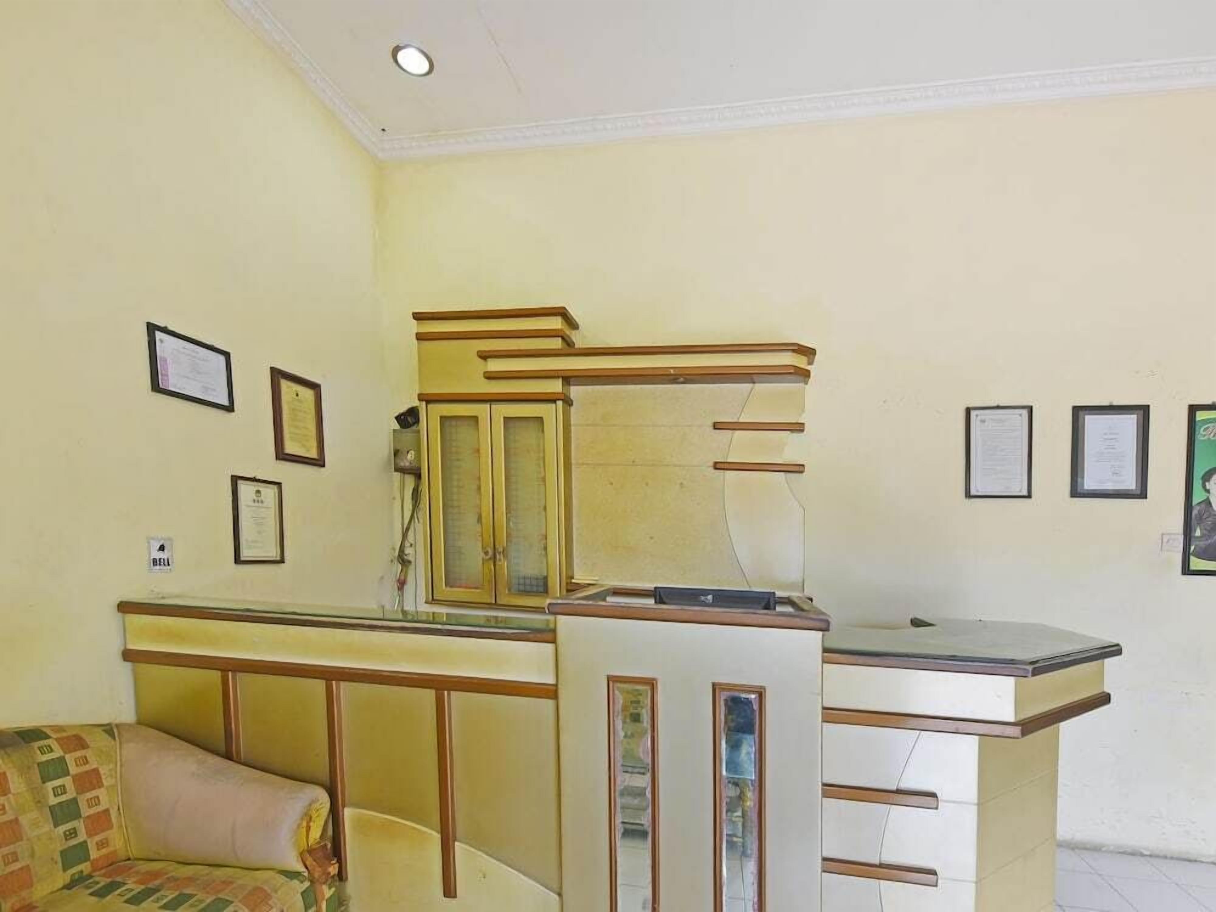 A room with a sofa, a desk, and a cabinet. There are framed certificates on the wall.