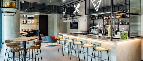 Un área de bar moderna con taburetes, una barra con botellas y un letrero de neón.