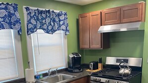 A kitchen with wooden cabinets, a stainless steel stove, and a coffee maker.