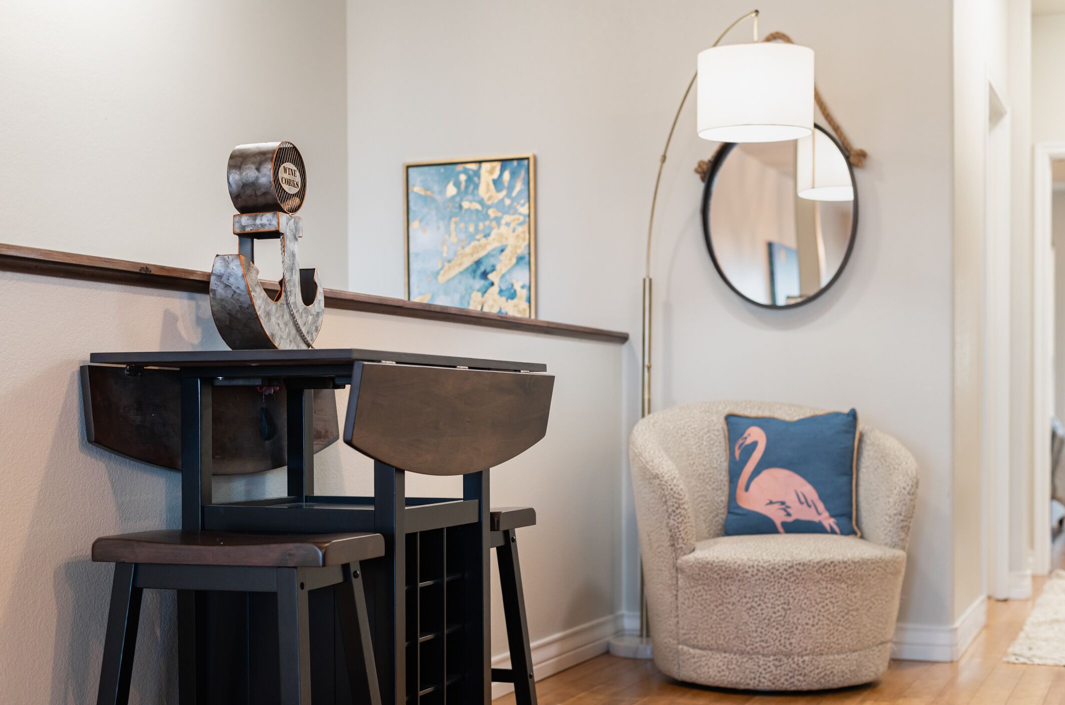 Un salon moderne au design minimaliste, comprenant une table basse en bois foncé, un fauteuil moelleux avec un coussin bleu et une lampe de sol contemporaine.