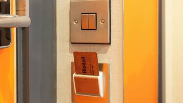 A hotel room door with a light switch and a card slot for room keys.