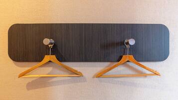 A wall-mounted wooden hanger with a metal hook, likely for hanging coats or bags.