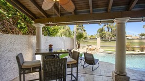 A covered patio area with a pool, wicker furniture, and a ceiling fan. - Quiet Desert Oasis on Golf Course w/ Heated Pool (Mesa)