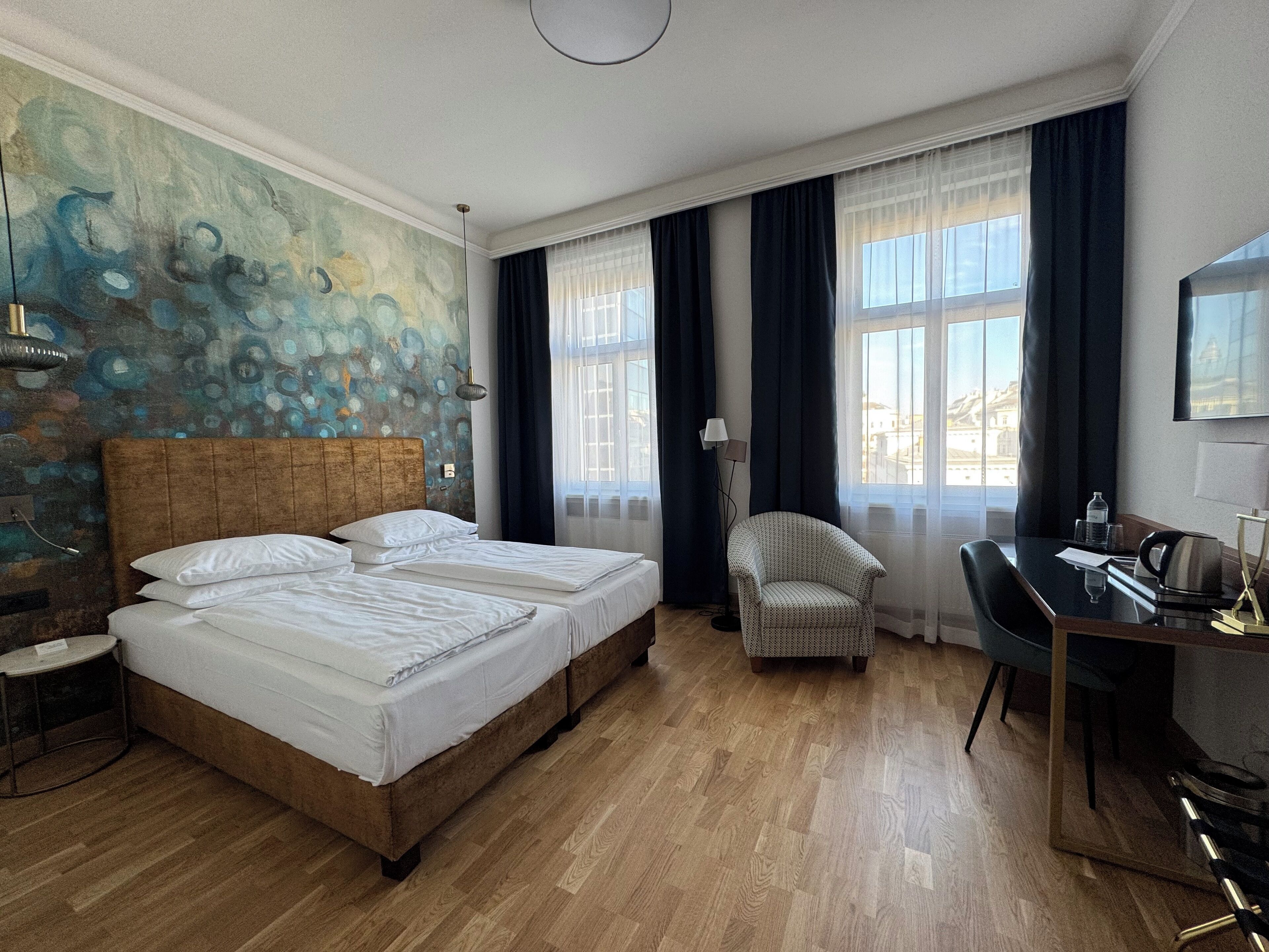 Habitación de hotel con una cama grande, un escritorio, una silla y un cuadro en la pared.
