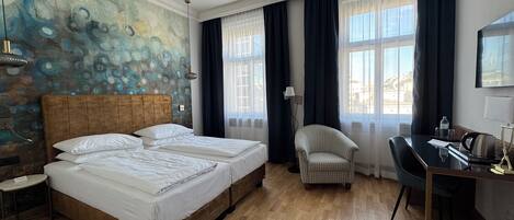 Habitación de hotel con una cama grande, un escritorio, una silla y un cuadro en la pared.