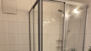 A bathroom with a glass-enclosed shower, a toilet, and a sink. - Gasthof Linde-Classico (Bad Mergentheim)