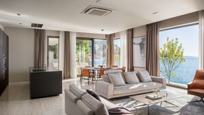 A modern living room with a sofa, coffee table, and a dining area. - New Villa, Comfort & Luxury, Beachfront, Prestigious Location, Full experience (Dubrovnik)