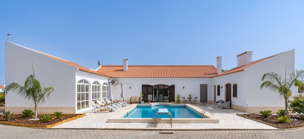 A pool area with a tiled roof, lounge chairs, and potted plants. - Quinta do Quartel - Évora (Évora)