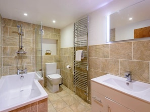 Un baño moderno con dos lavamanos, ducha e inodoro.