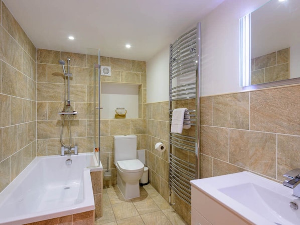 Un baño moderno con bañera, inodoro y lavamanos.