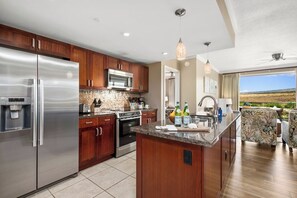 Una cocina moderna con electrodomésticos de acero inoxidable, armarios de madera y una isla grande con fregadero.