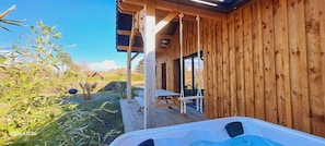 A wooden cabin with a hot tub, picnic table, and a covered outdoor area. - Les Bord'Océanes Villa Marensine **** with a pool, sauna, and private spa (Vielle-Saint-Girons)
