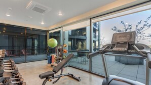 A modern gym with exercise equipment, large windows, and a view of the outdoors. - LCF - Downtown SLC - 1BR/1BA - CoWork + Gym - Near Delta Center - Garage (Salt Lake City)