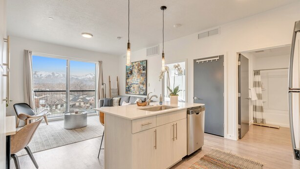 A modern kitchen with a large island, a dining area with a view, and a bathroom with a shower and toilet. - LCF - Downtown SLC - 1BR/1BA - CoWork + Gym - Near Delta Center - Garage (Salt Lake City)