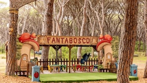 A wooden playhouse with a sign reading "FANTABOSCO" surrounded by trees. - Comfort Lodge Maremma (Grosseto)