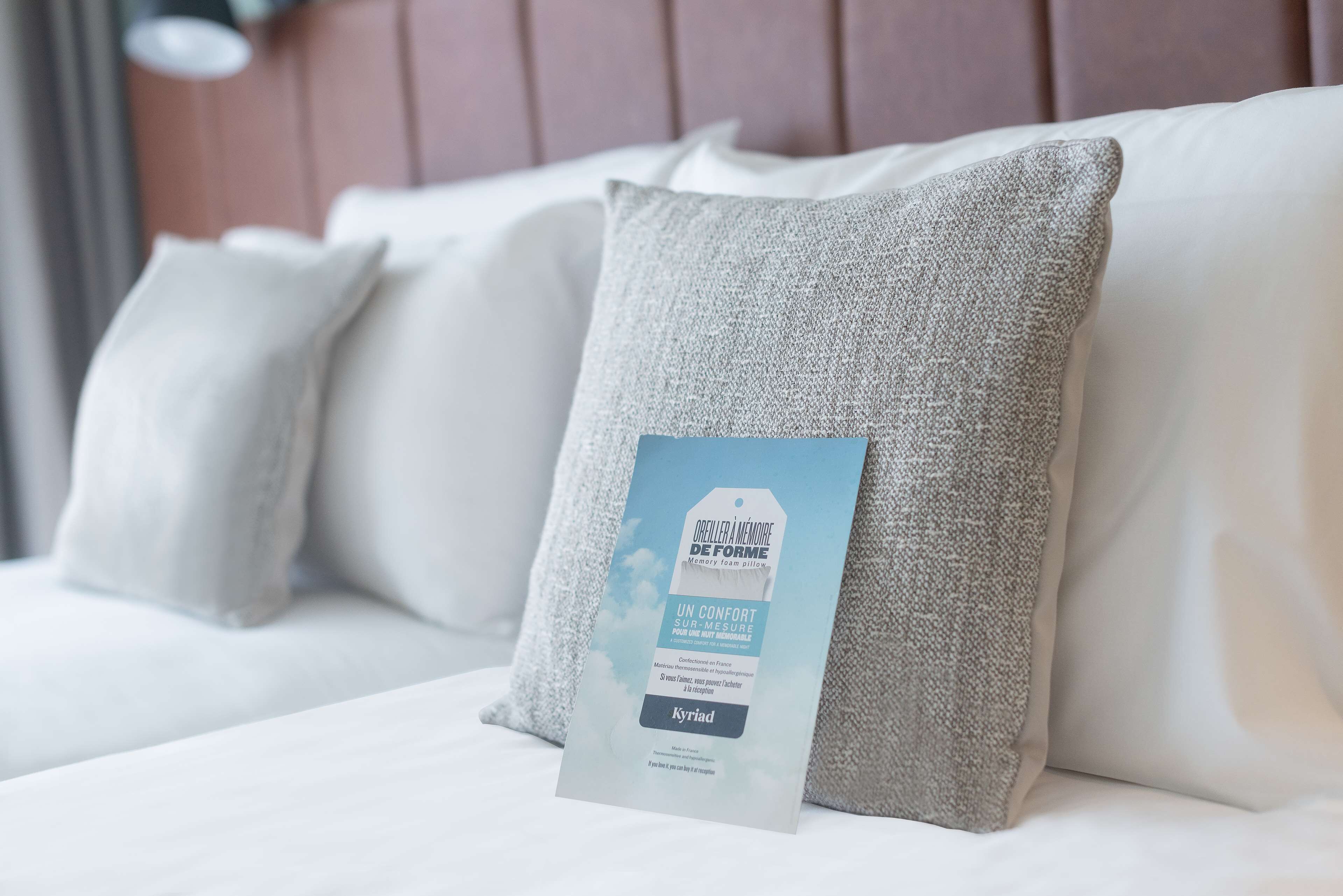 Una cama de hotel con un almohadón y una etiqueta.