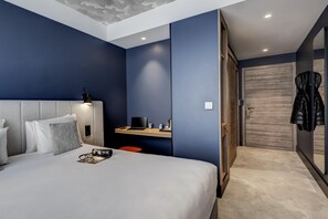 A modern hotel room with a large bed, a desk with a laptop, and a coat rack. - Kyriad Lyon Ouest - Limonest (Limonest)