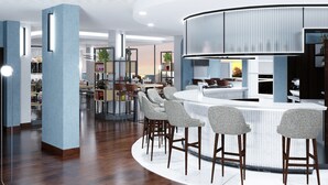 Een moderne bar met een gebogen toonbank, barkrukken en een zithoek met tafels en stoelen.