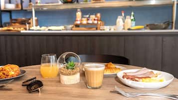 Ein Esstisch mit einem Croissant, einer Omelett und Kaffee.