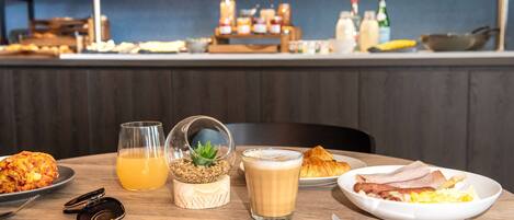 A breakfast table with a croissant, omelette, and coffee.