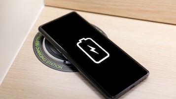 Een smartphone die oplaadt op een oplaadstation.