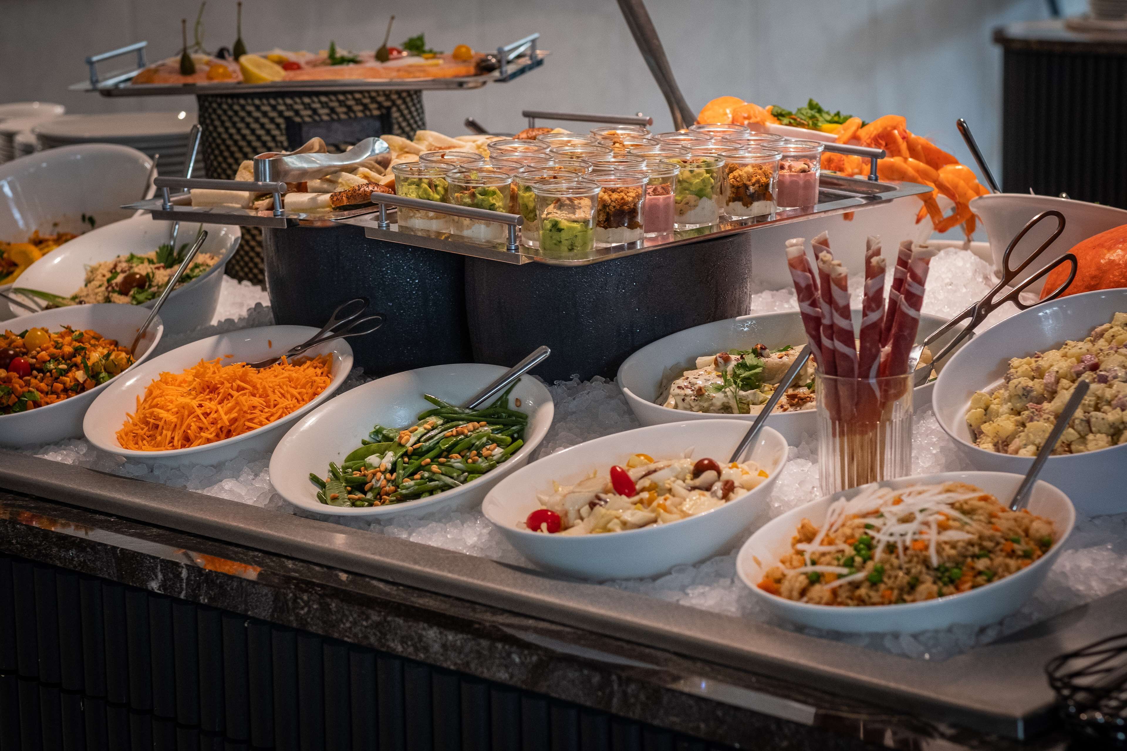 A buffet with various dishes and food items displayed on a table.
