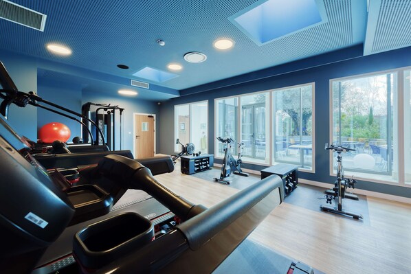 A gym with treadmills, exercise balls, and weight machines. - Golden Tulip Lyon Ouest Techlid - Hotel and Spa (Limonest)