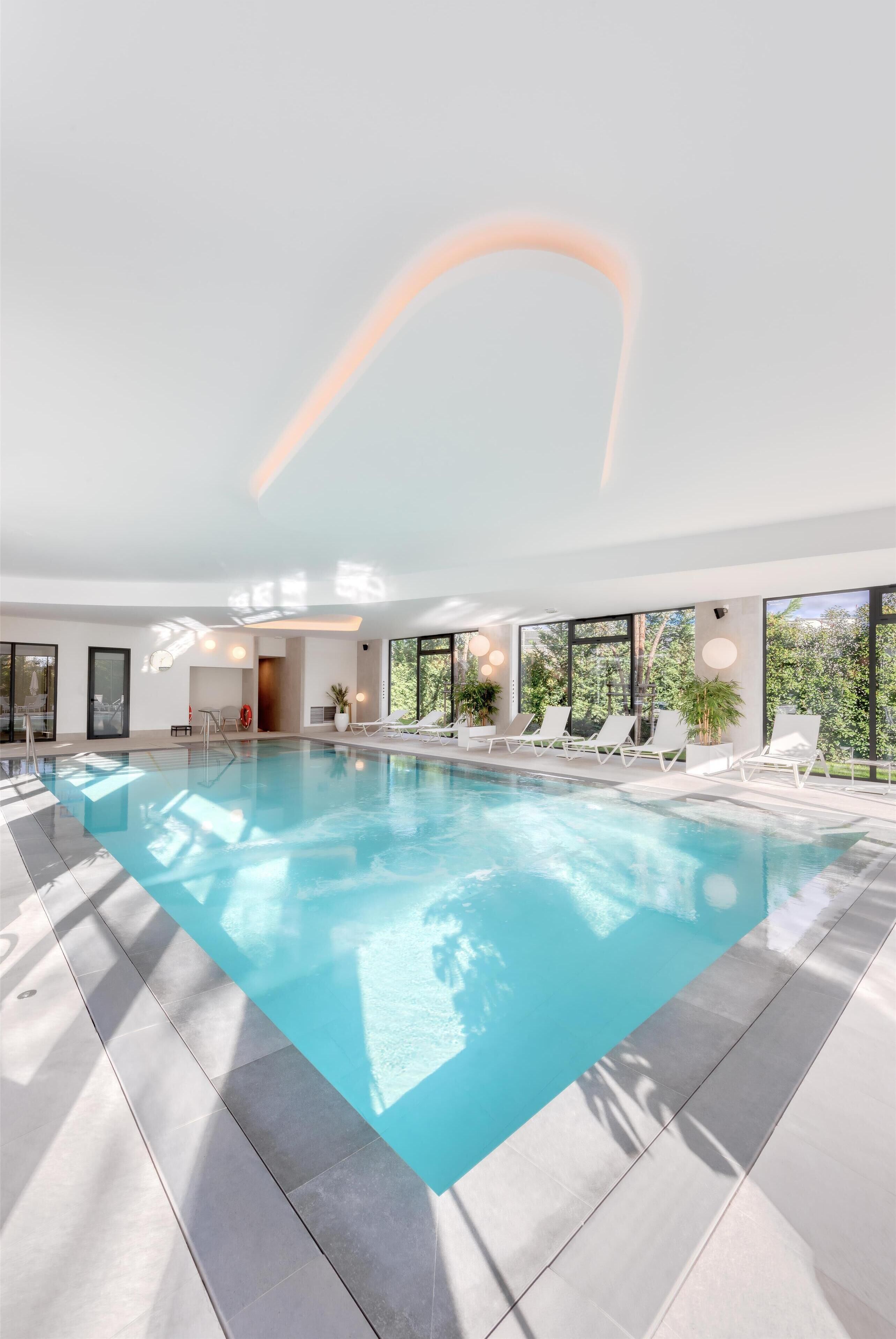 Una piscina techada, sillones reclinables de piscina