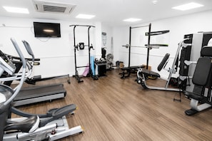 A gym with treadmills, weight machines, and a pull-up bar area.
