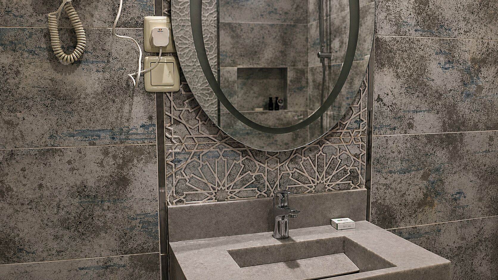 A bathroom with a sink, mirror, and towel rack.