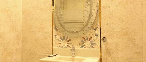 A bathroom with a sink, mirror, and decorative tiles.