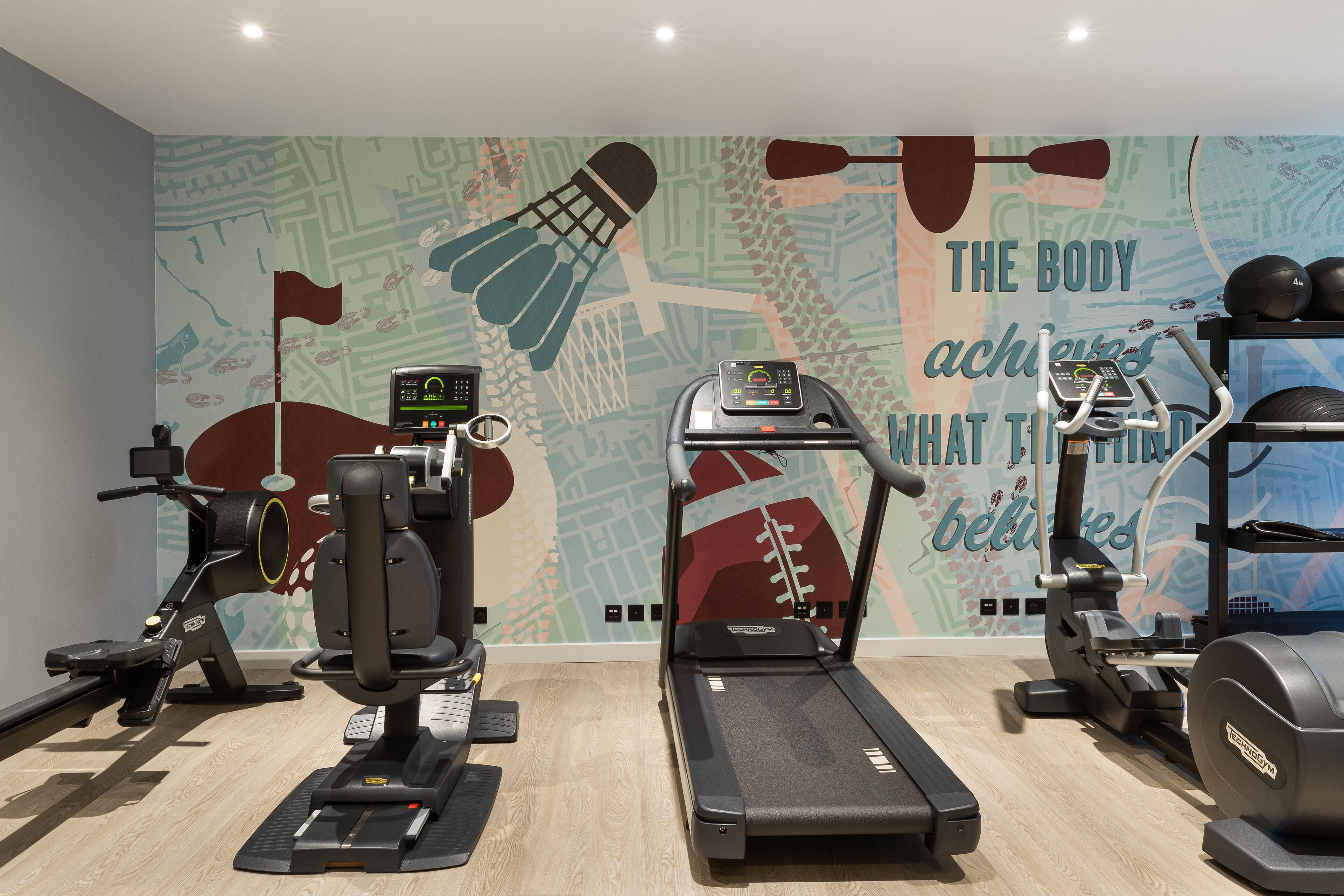 Un gimnasio con cintas de correr, elípticas y equipo de pesas.