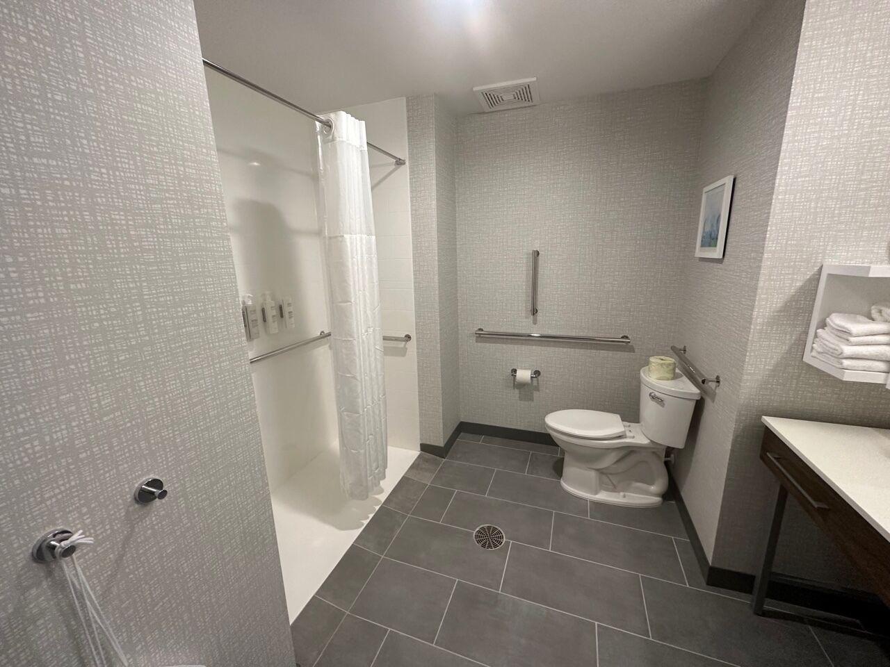 A compact bathroom with a shower, toilet, and sink.