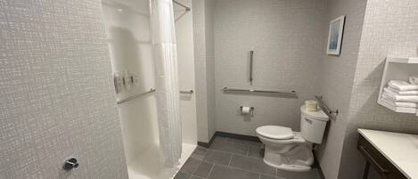 A compact bathroom with a shower, toilet, and sink.