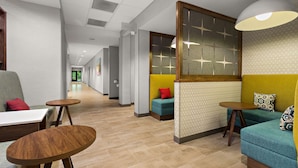 A hotel lobby with seating areas, a reception desk, and a sign indicating the location of restrooms. - Hampton Inn & Suites Ruskin I-75 (Ruskin)